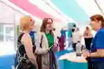 A student and their parent talking to a member of staff at an open day