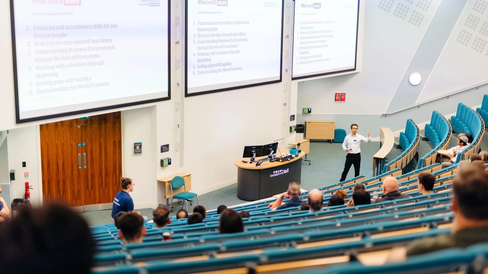 A group of students learning in a large lecture theatre