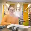 Student smiling on a table at the library