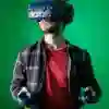 Game design student in a red t-shirt wearing a virtual reality headset in front of a green screen