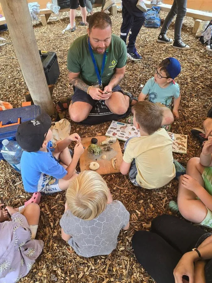 A group of young students sat on the ground