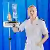 A student nurse with blonde hair wearing a white uniform