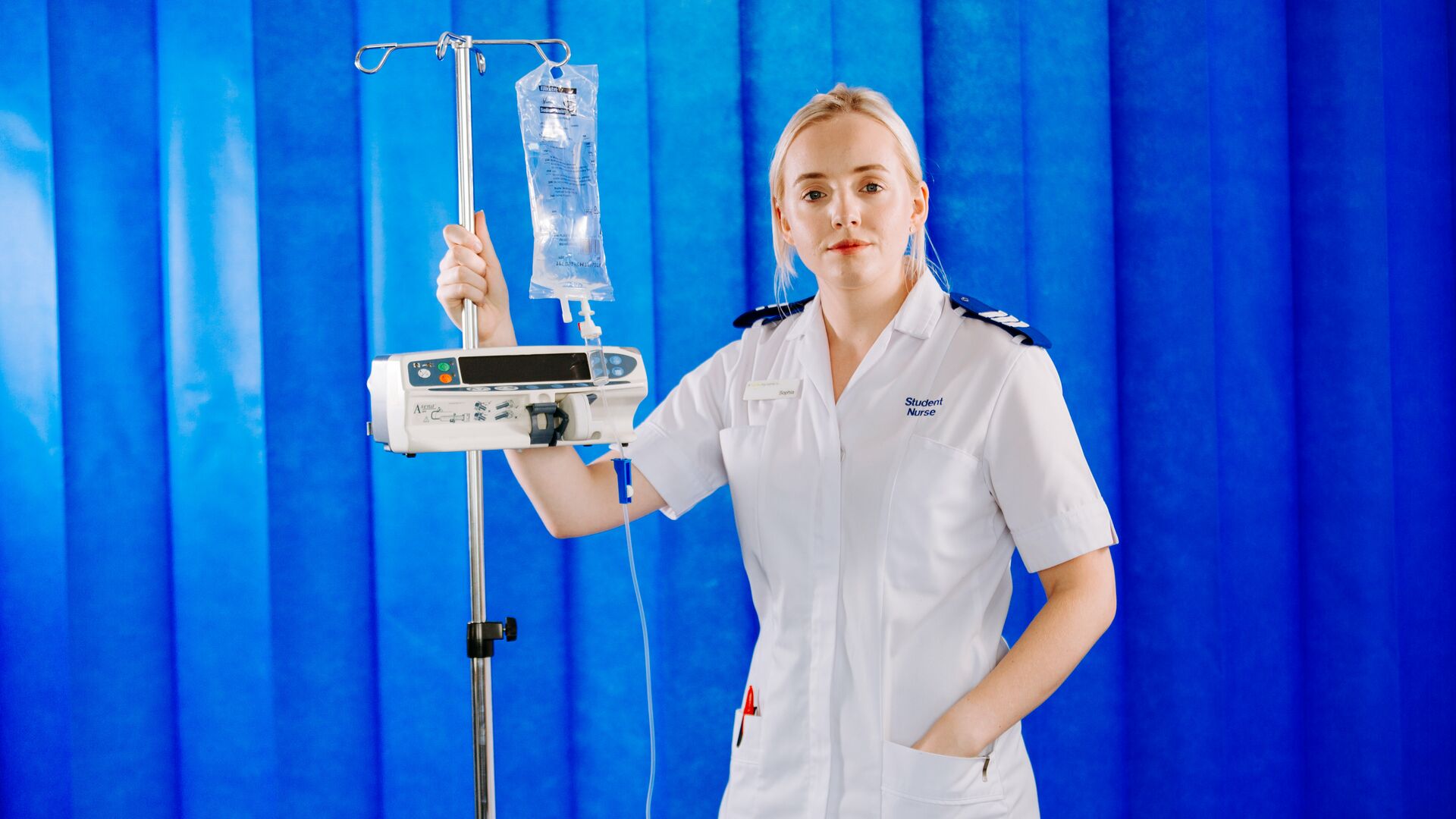 A student nurse with blonde hair wearing a white uniform