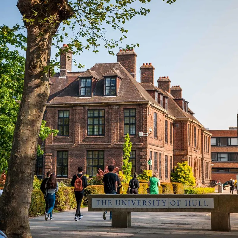 Students walking past University Sign