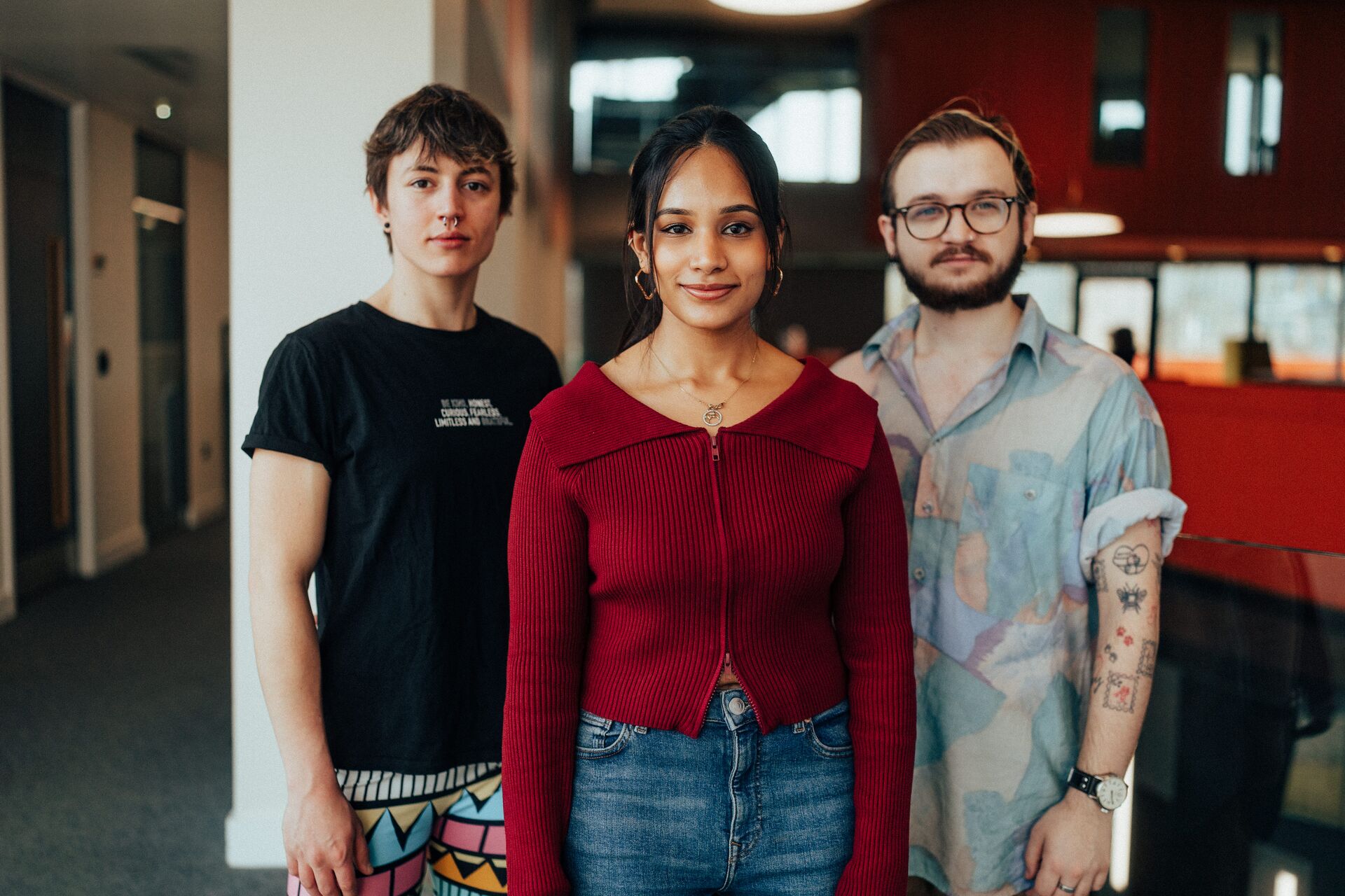 Three of Hull’s students stand confidently together on an elevated walkway in the modern Allam Medical Building