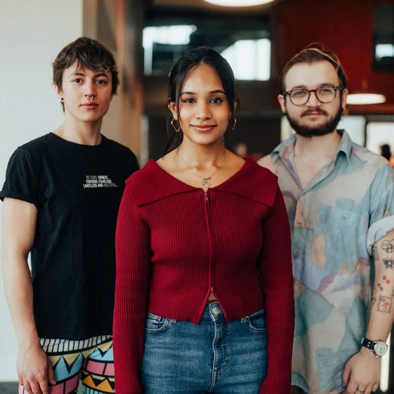 Three of Hull’s students stand confidently together on an elevated walkway in the modern Allam Medical Building