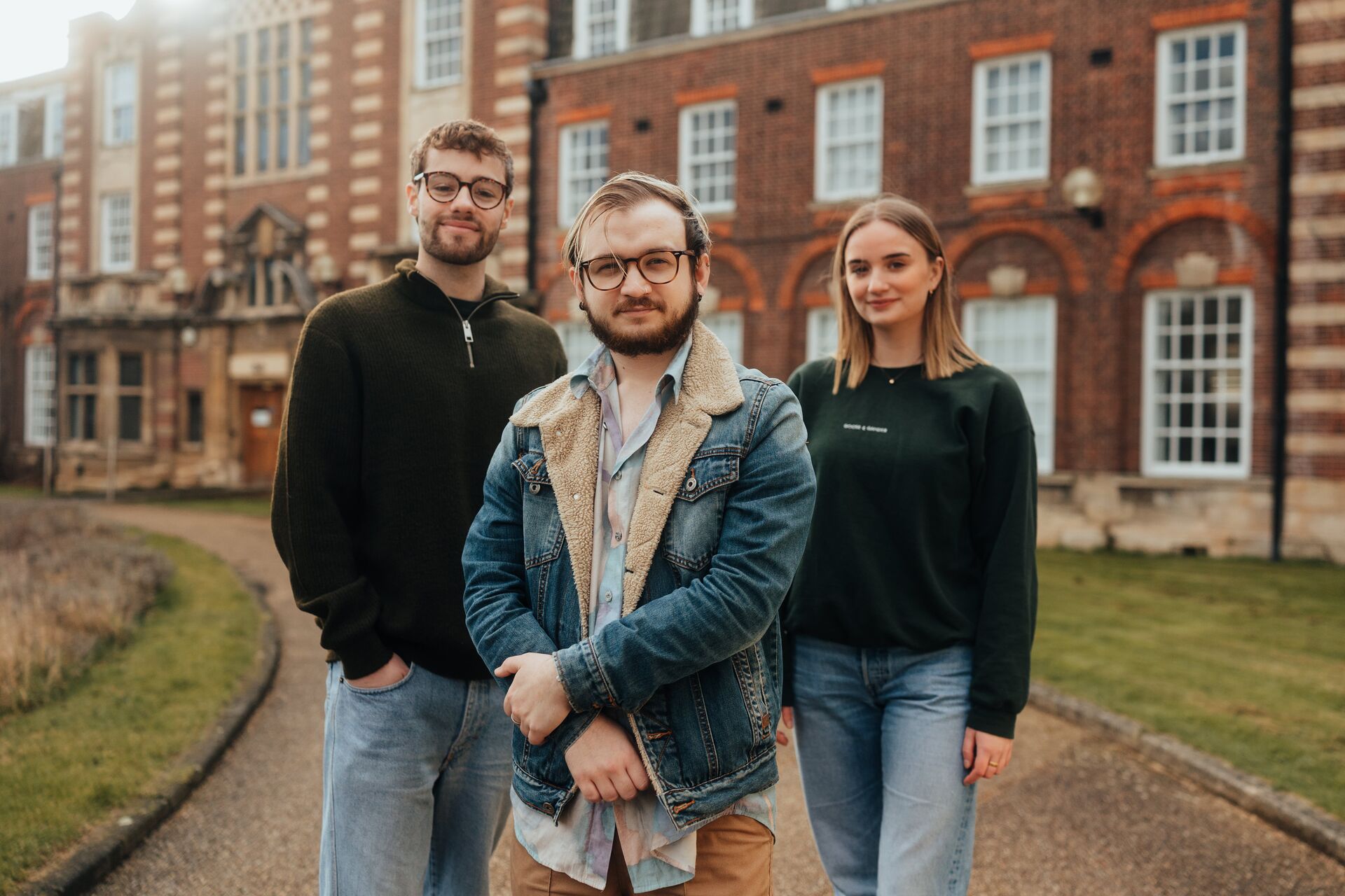 Three of Hull’s students stand confidently together in front of the business schools' beautiful listed buildings