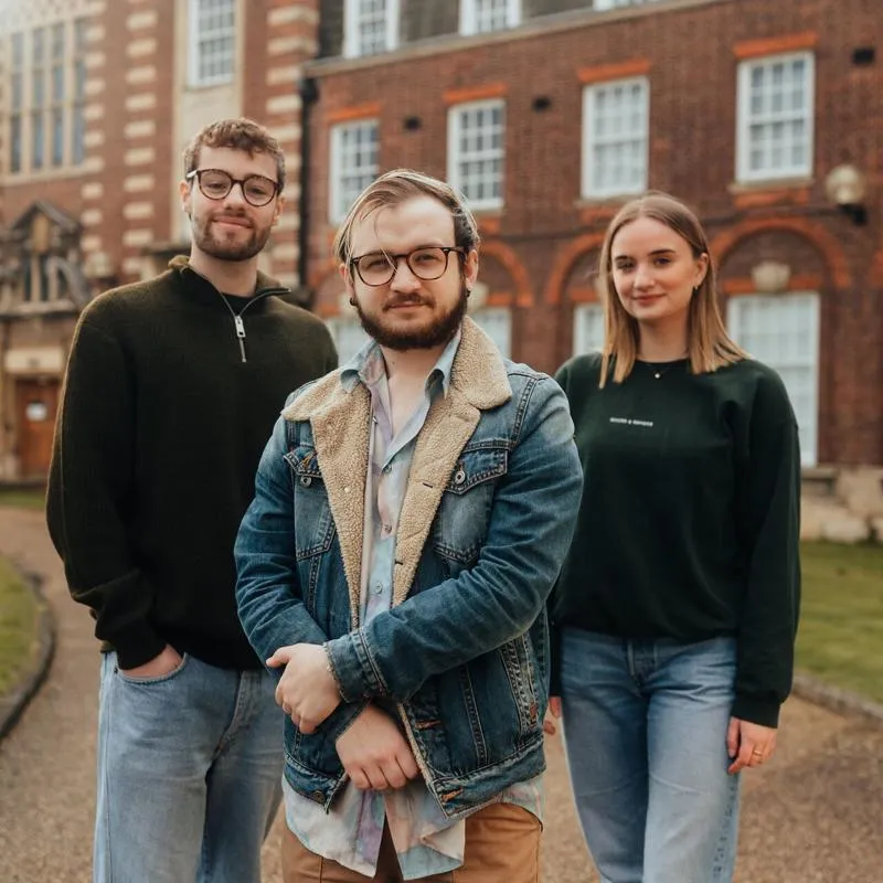 Three of Hull’s students stand confidently together in front of the business schools' beautiful listed buildings