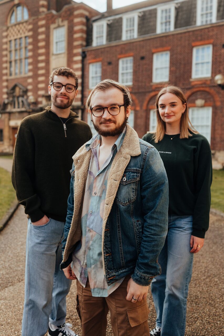 Three of Hull’s students stand confidently together in front of the business schools' beautiful listed buildings