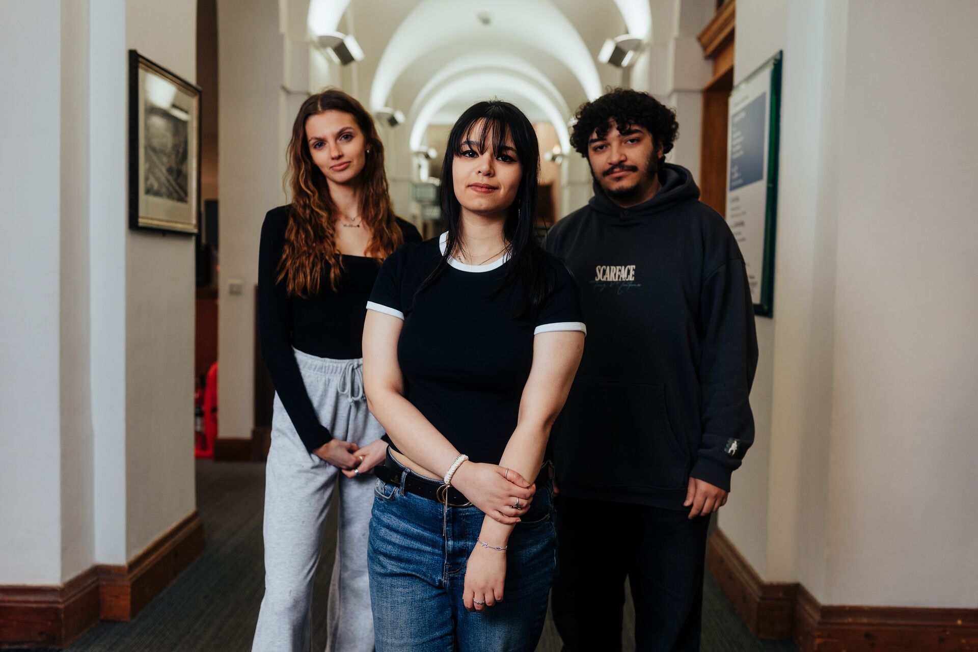Three of Hull’s students stand confidently together in a brightly lit corridor in the business school