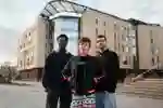 Three of Hull’s students stand confidently together in front of the modern Allam Medical Building