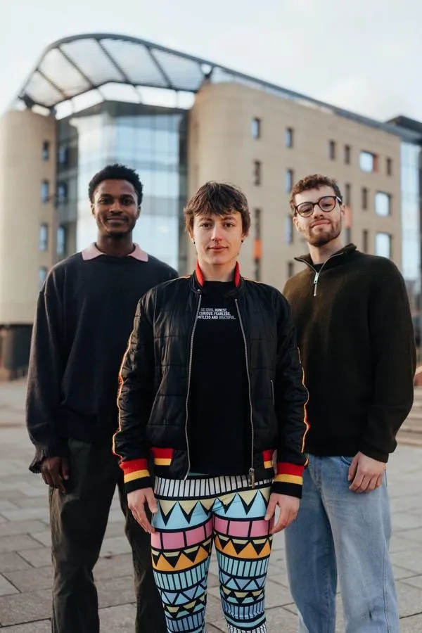 Three of Hull’s students stand confidently together in front of the modern Allam Medical Building