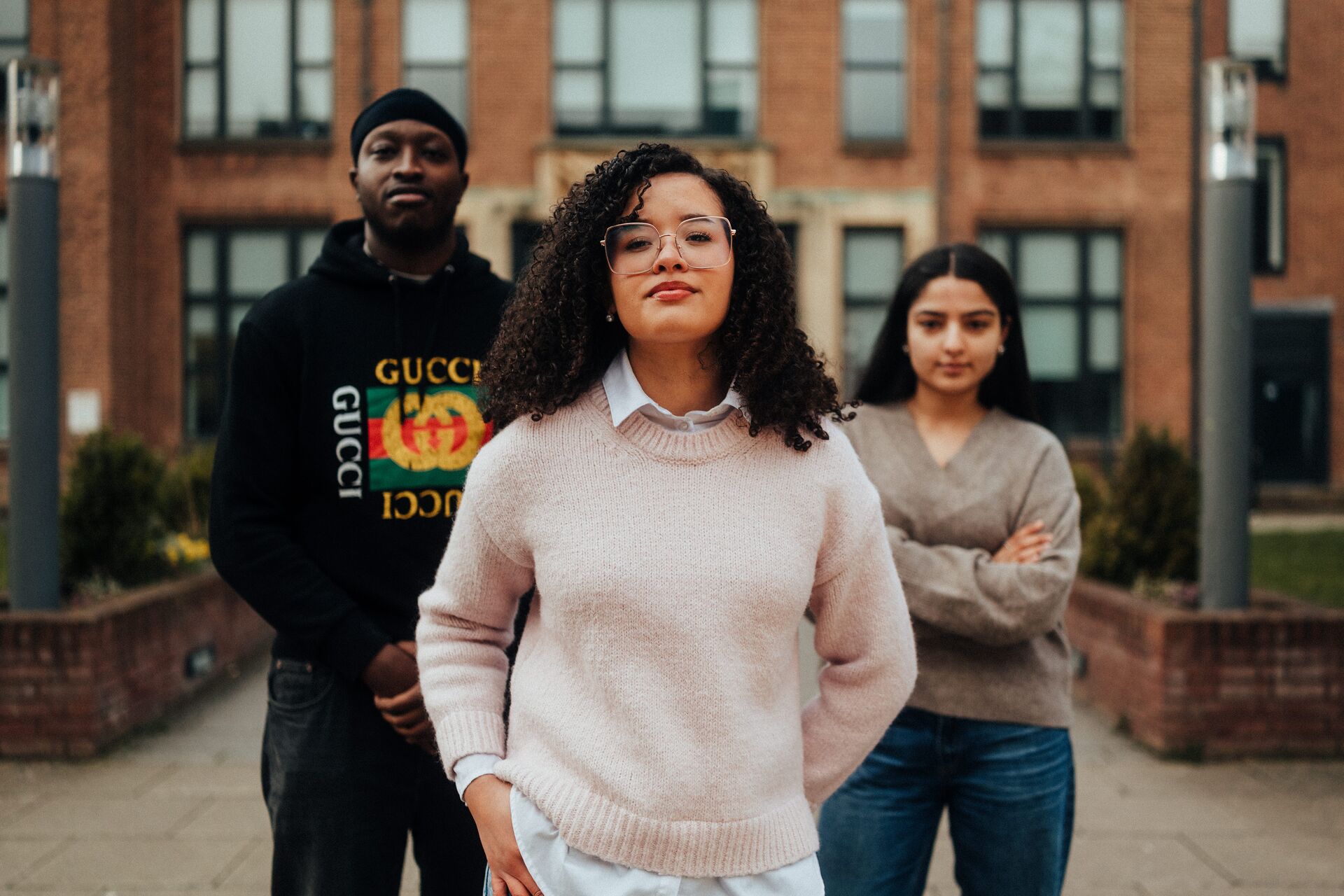 Three of Hull’s students stand confidently together in front of an ornate entrance to the Library