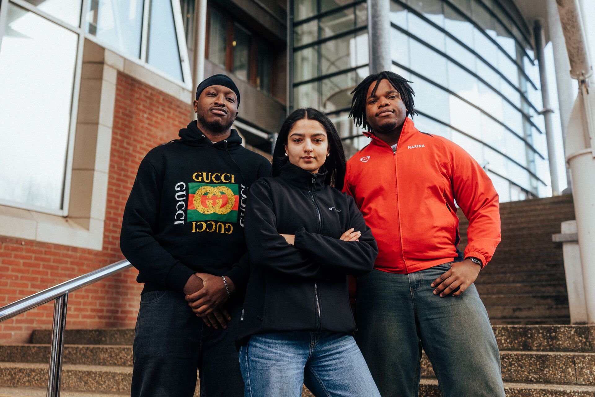 Three of Hull’s students stand confidently together on steps in front of the students' union