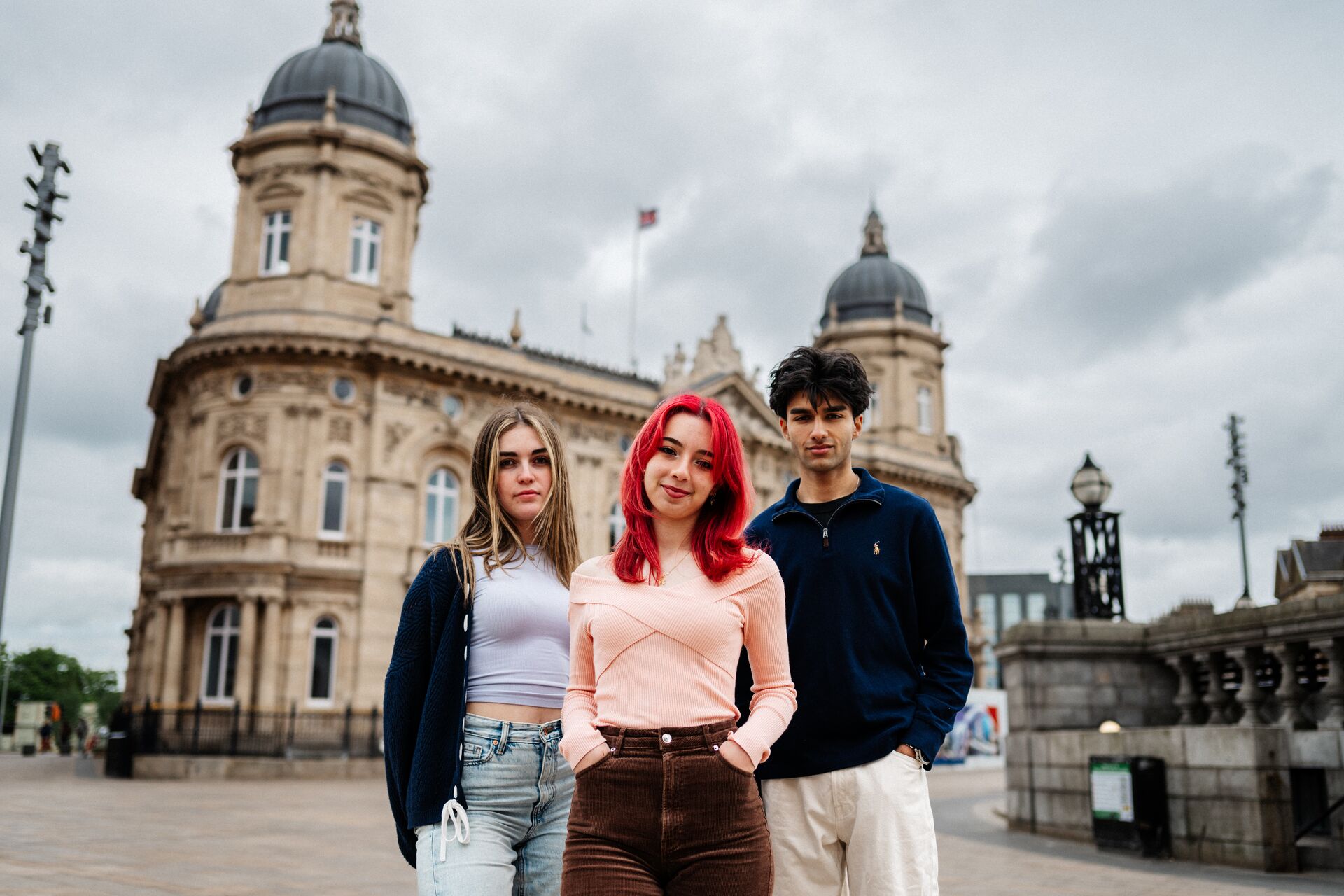 Three of Hull’s students stand confidently together in front of the Maritime Museum