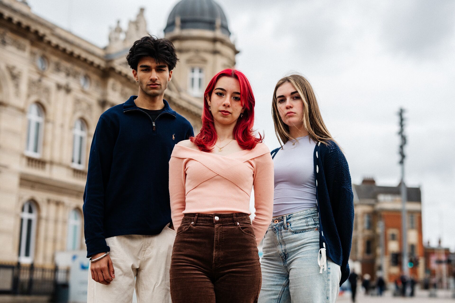 Three of Hull’s students stand confidently together in front of the Maritime Museum