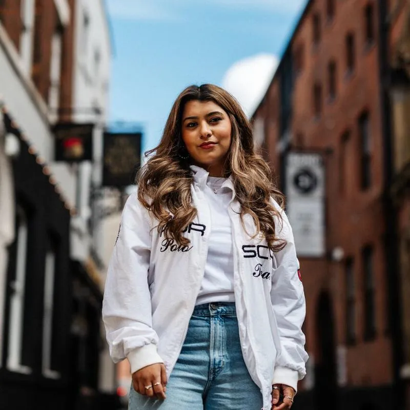 A female student in baggy jeans stands confidently on a cobbled street in Hull's Old Town