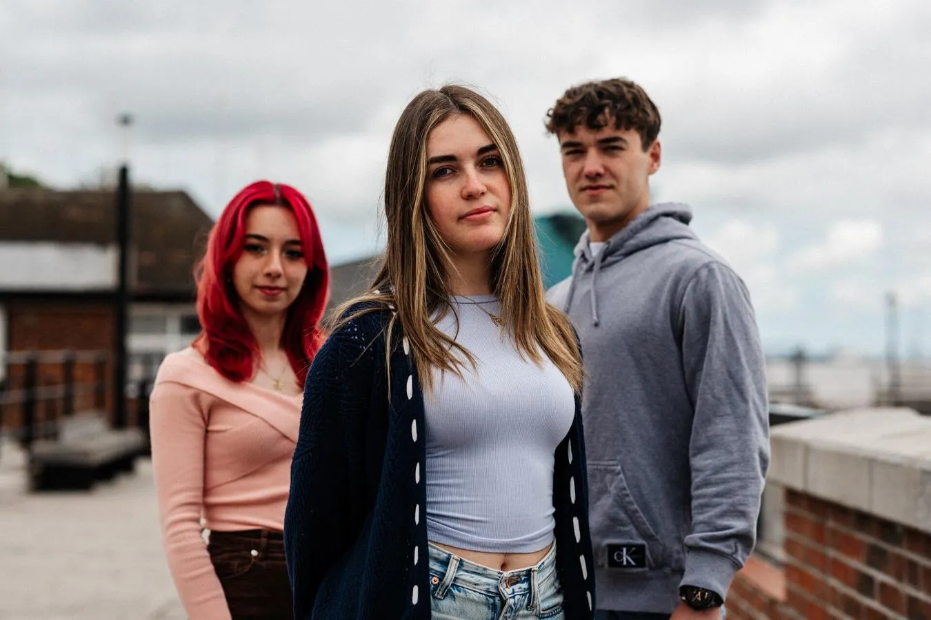 Three of Hull’s students stand confidently together in front of The Deep, Hull's iconic aquarium