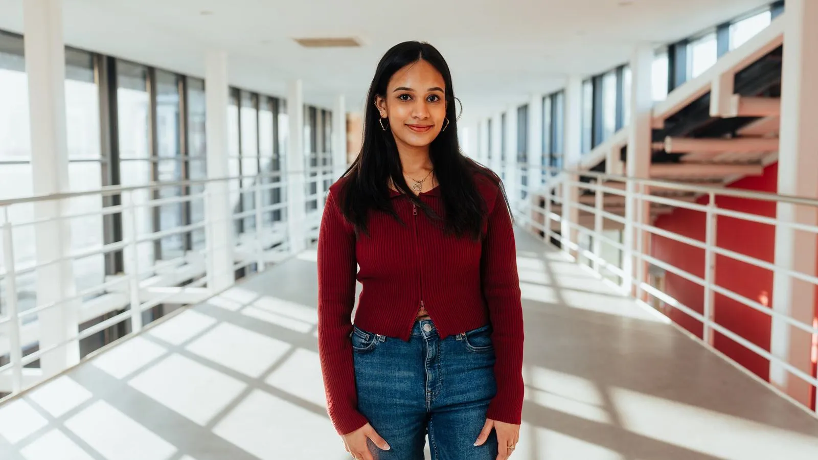 Student posing on balcony in business building