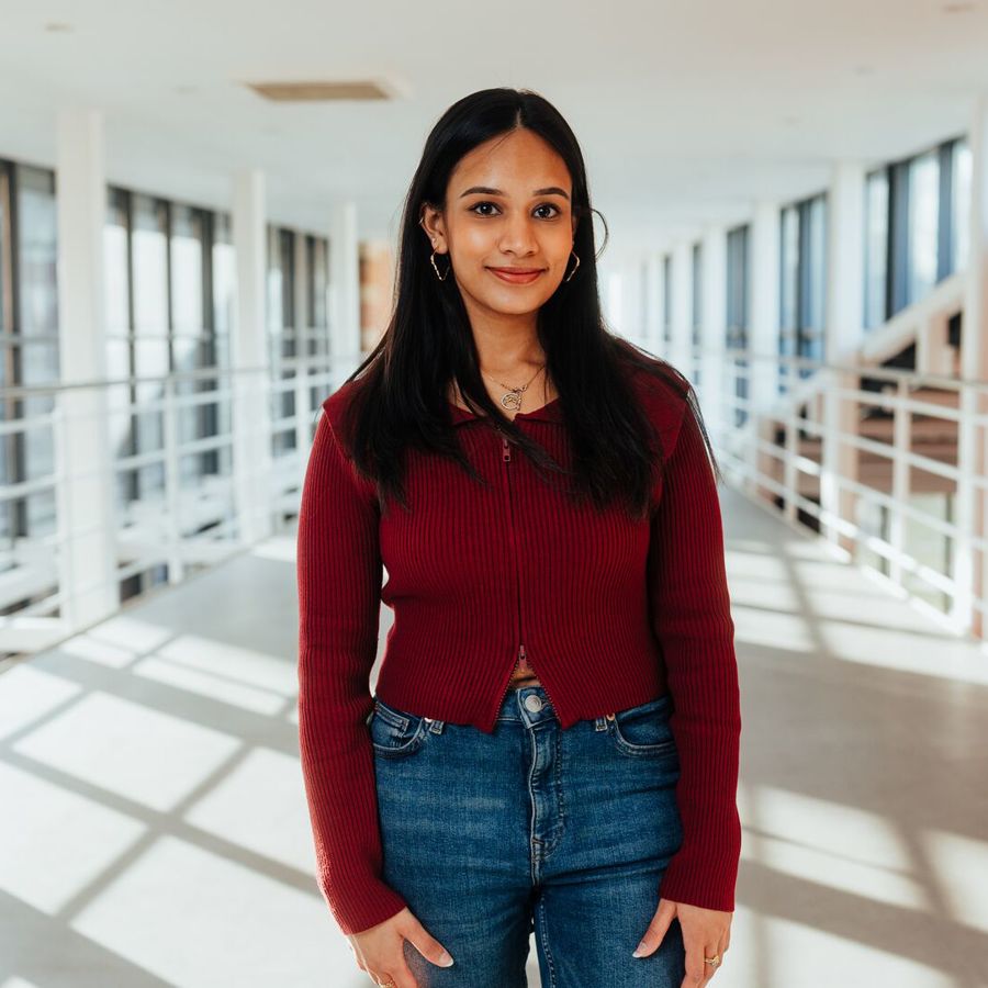 Student posing on balcony in business building
