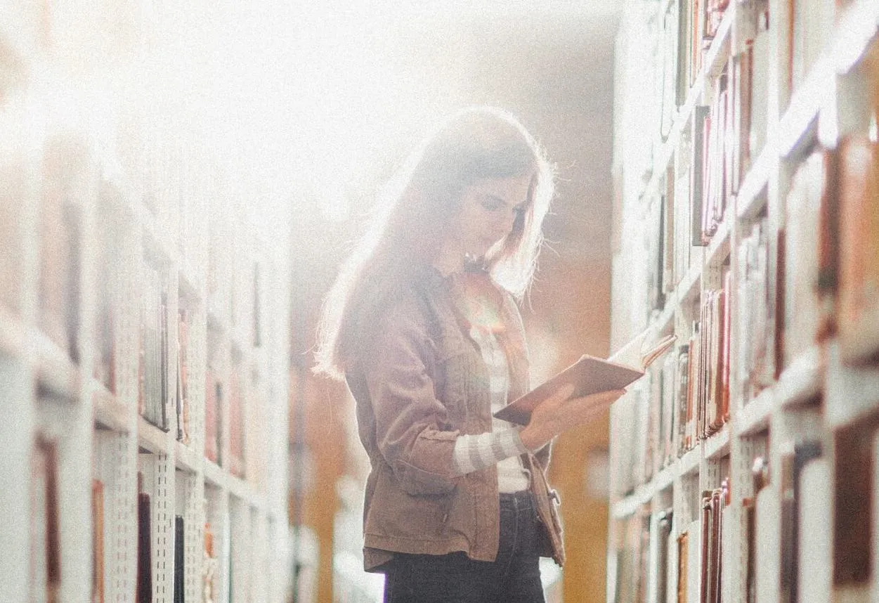 Student stood reading in library