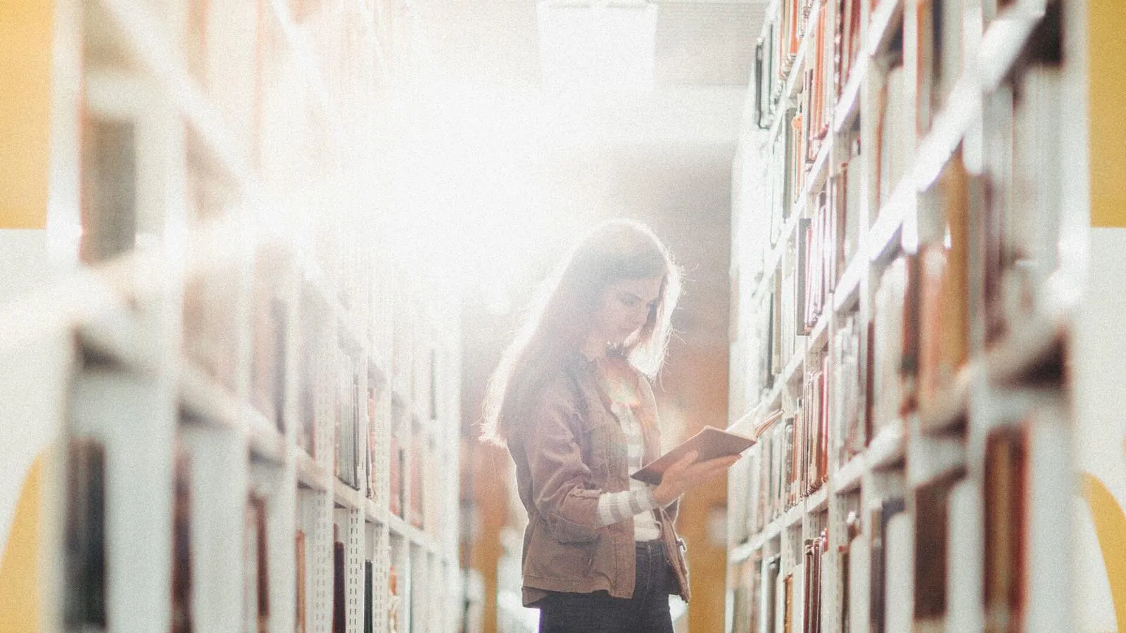 Student stood reading in library