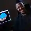 A student sat in front of a computer with a picture of a brain on it