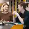 Two students sat in the library smiling