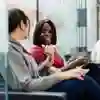 two students on chairs in business lounge chatting