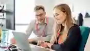 A student and supervisor working at a desk on placement