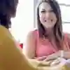 Social work student sat with their arms crossed and smiling