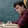 A student is studying maths in front of a chalkboard