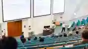 A group of students learning in a large lecture theatre