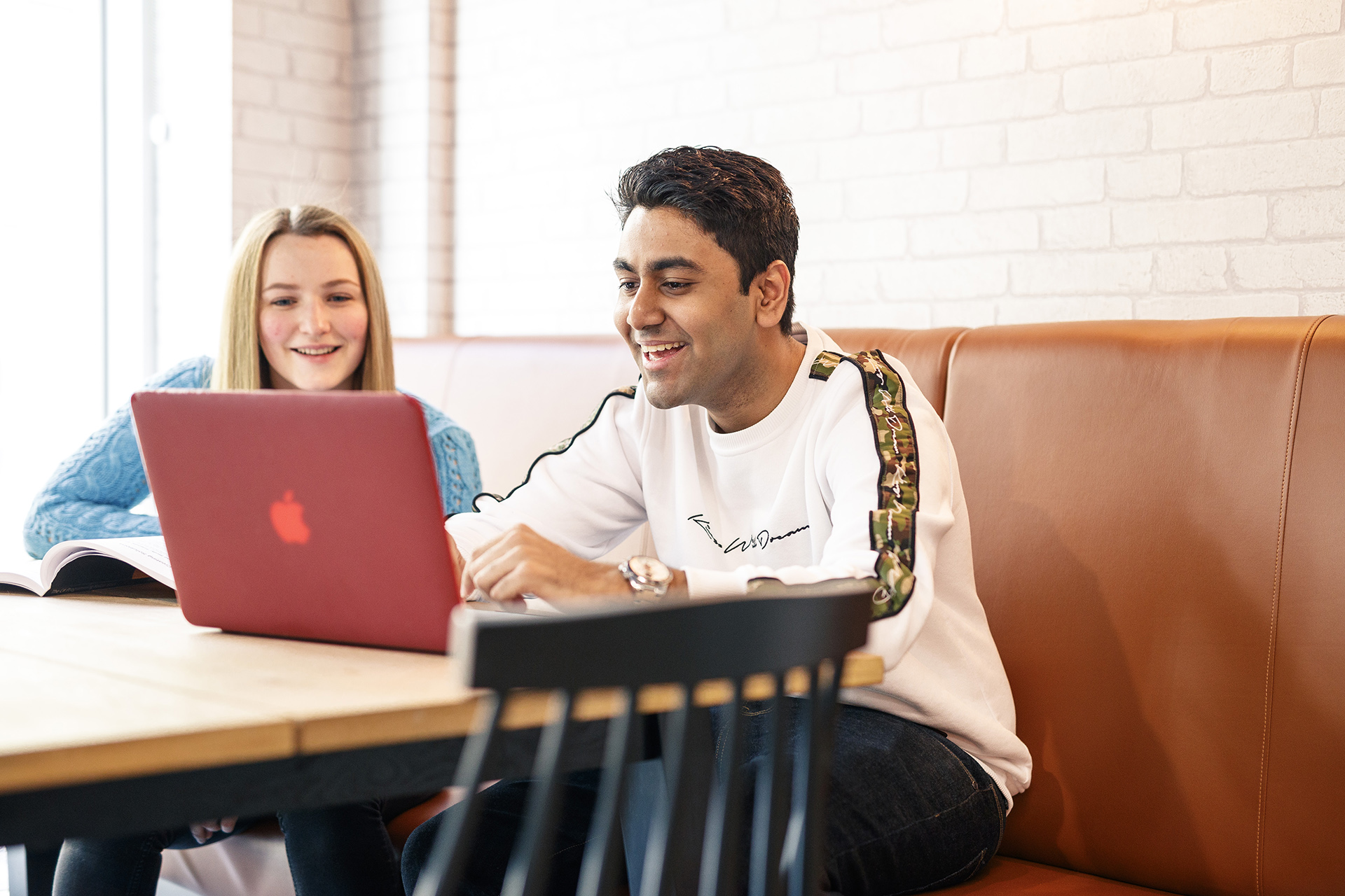 Two students gathered around a laptop
