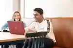 Two students gathered around a laptop