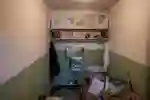 Prison cell interior displaying artwork and art materials