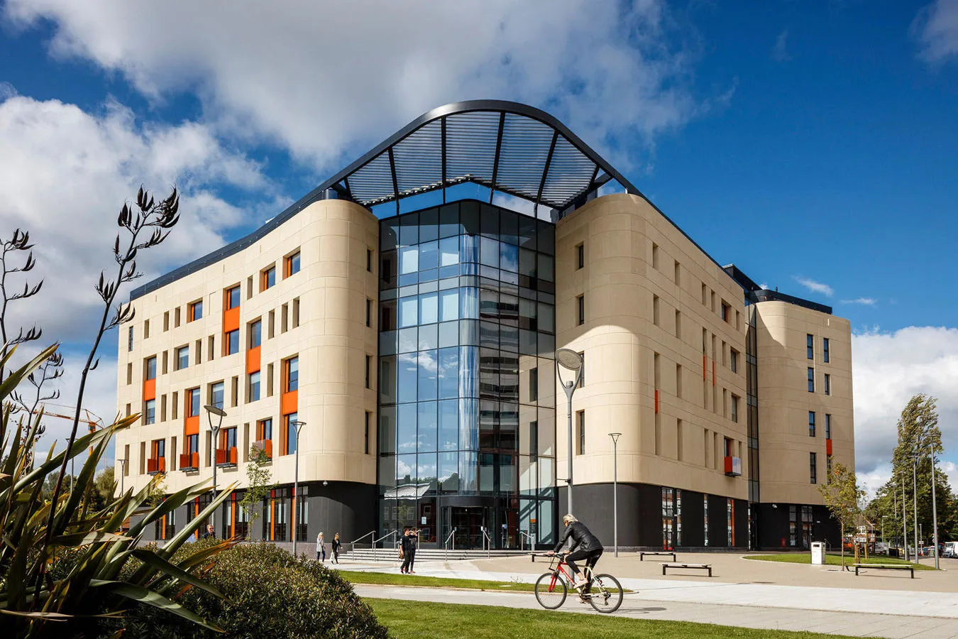 The Allam Medical Building a large modern building of light coloured brick and glass on a sunny day with blue sky