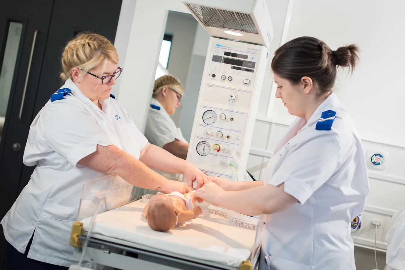 Midwifery students practice on a dummy