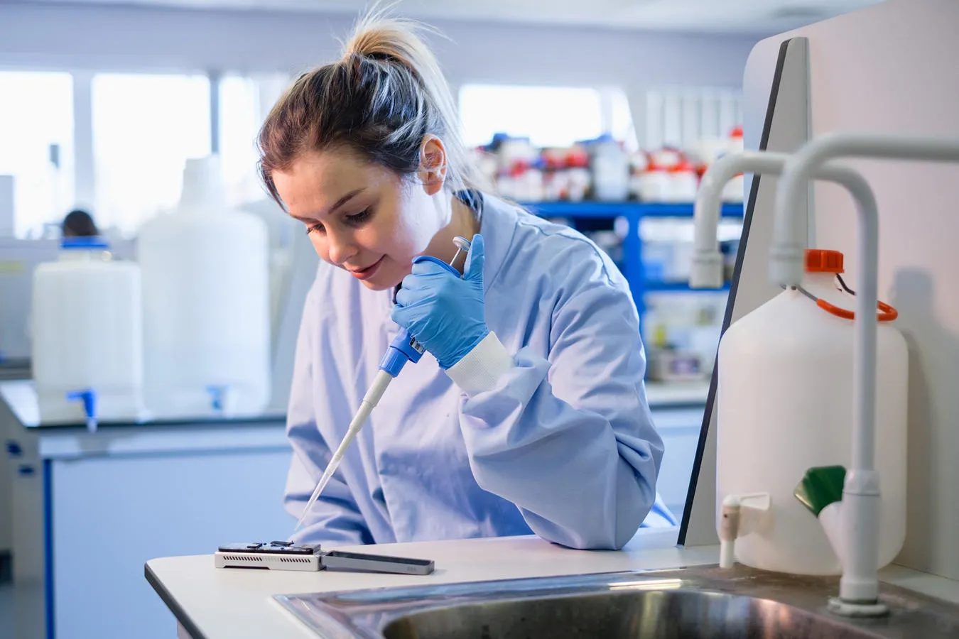 PhD student Amber uses a pipette in a medical laboratory