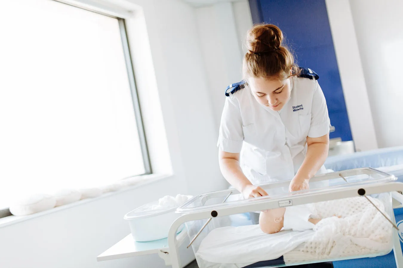 Midwife caring for a newborn baby in a hospital.