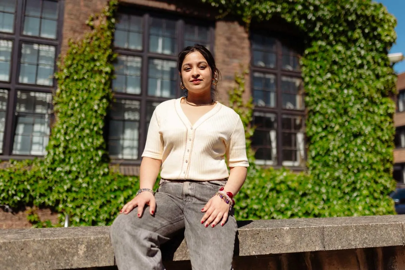 Avani Kapoor, BA Music (Music Production) student sitting on a wall outside Venn