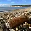 A rusted aerosol can in the foreground of a beach scene