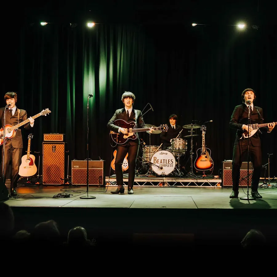 Four performers on stage as part of the Beatles Complete live tribute act