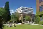The exterior of the Brynmor Jones library with students sitting on the grass in the foreground