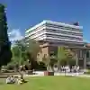 The exterior of the Brynmor Jones library with students sitting on the grass in the foreground