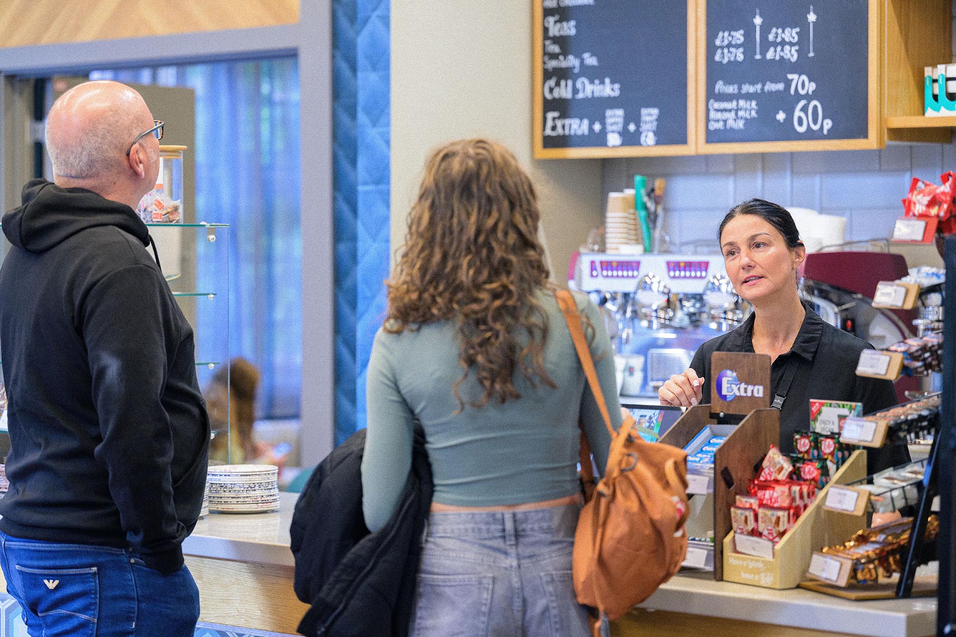 A student and her dad are served by one of our baristas at an on-campus cafe