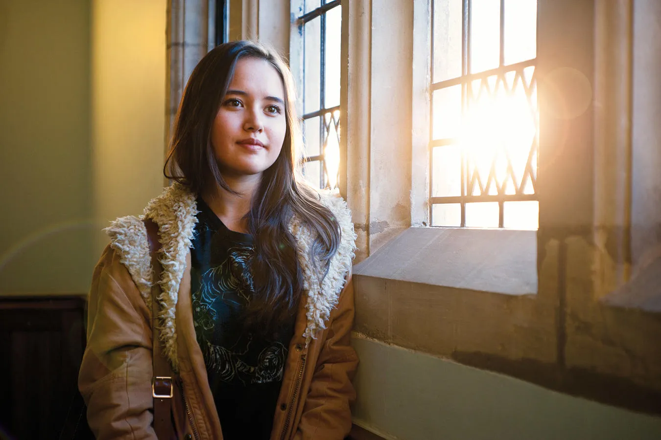 Politics & Philosophy student Carolyn Ward leaning against window in university building