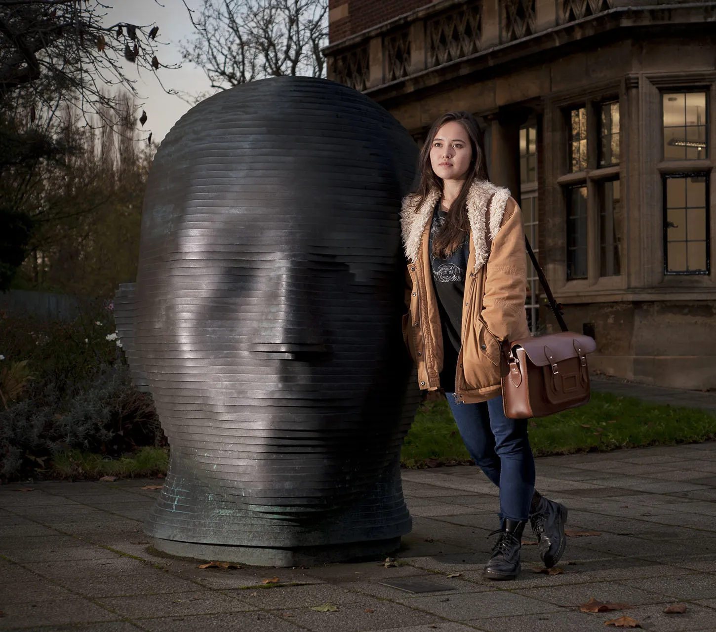 Philosophy student Carolyn Ward leaning against head sculpture at the University of Hull campus