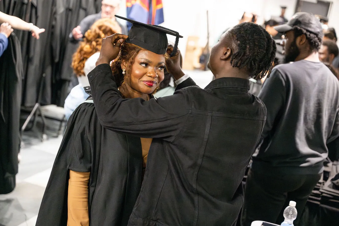 Student getting thier mortar board hat fiited at graduation