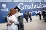 Student and reletive hugging after collecting graduation certificate
